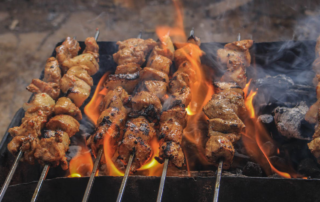 A delicious BBQ platter with ribs, sausage, and sides served on a wooden board.