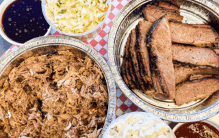 A tablecloth covered with various dishes including barbecue and sauces