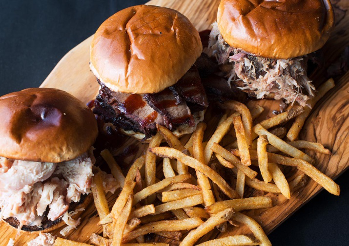 This photo shows some burgers and fries on a table.
